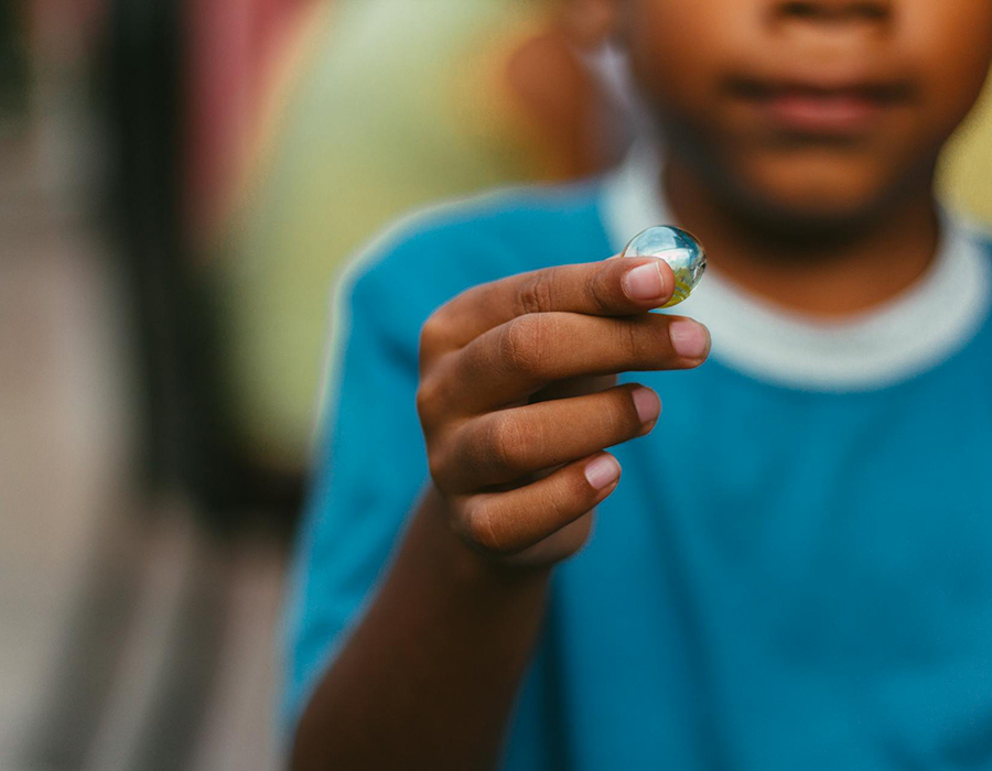 niño jugando canicas